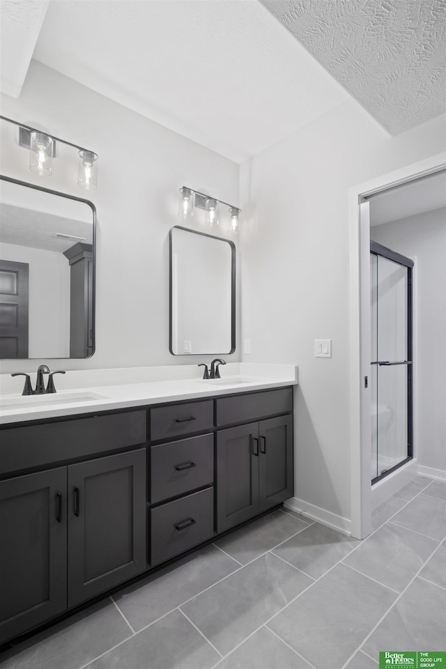 bathroom with vanity, tile patterned flooring, a shower with door, and a textured ceiling