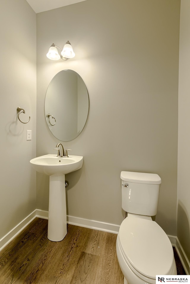 bathroom featuring wood-type flooring and toilet