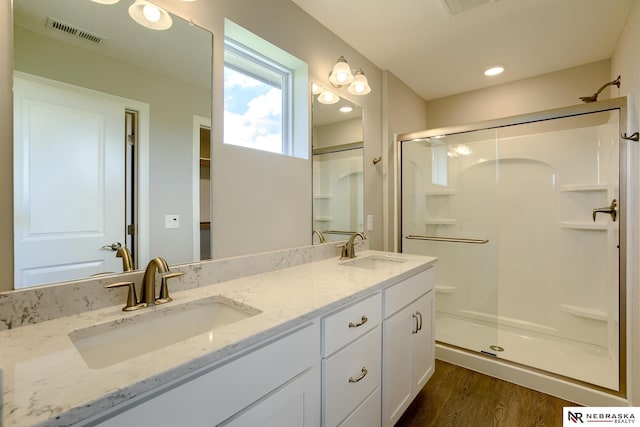 bathroom with vanity, hardwood / wood-style flooring, and a shower with shower door