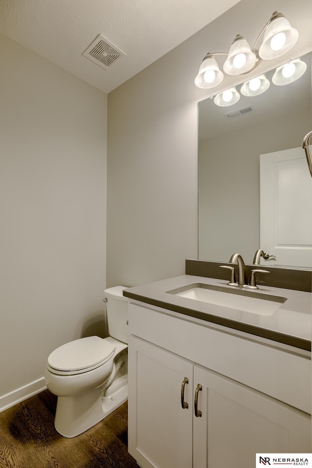 bathroom featuring vanity, hardwood / wood-style floors, and toilet