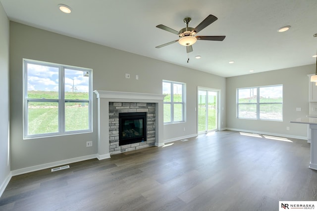 unfurnished living room with ceiling fan, plenty of natural light, and dark hardwood / wood-style floors