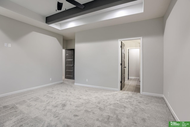 carpeted empty room featuring ceiling fan and beam ceiling