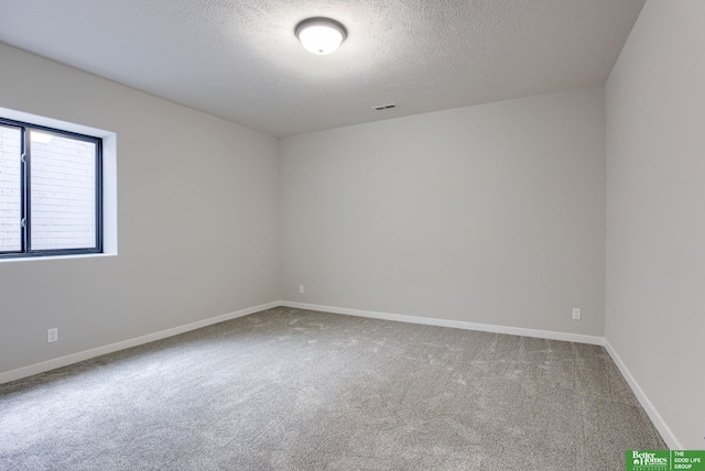 carpeted spare room featuring a textured ceiling