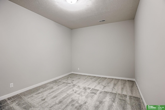 unfurnished room featuring carpet and a textured ceiling