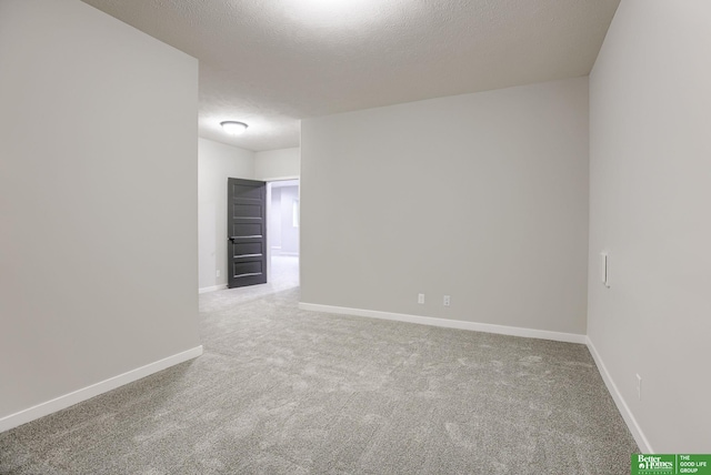 unfurnished room with carpet flooring and a textured ceiling