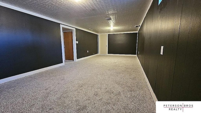 unfurnished room with carpet, a textured ceiling, and wood walls