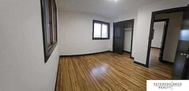 unfurnished bedroom with hardwood / wood-style flooring and a closet