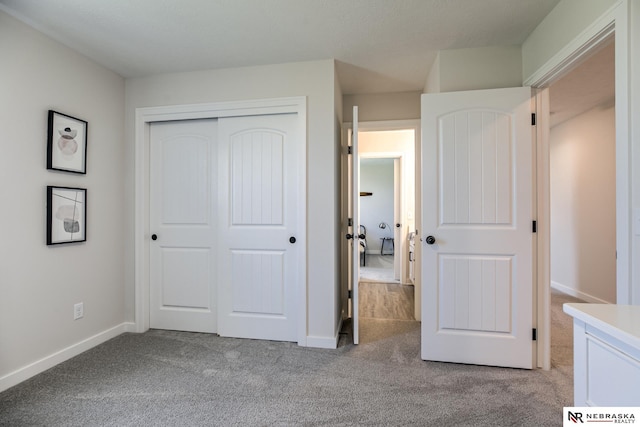 unfurnished bedroom featuring light colored carpet and a closet