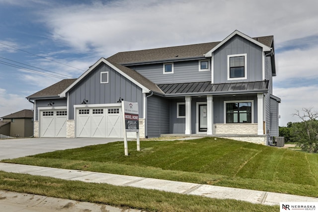 view of front of property with a garage, a front yard, and central air condition unit