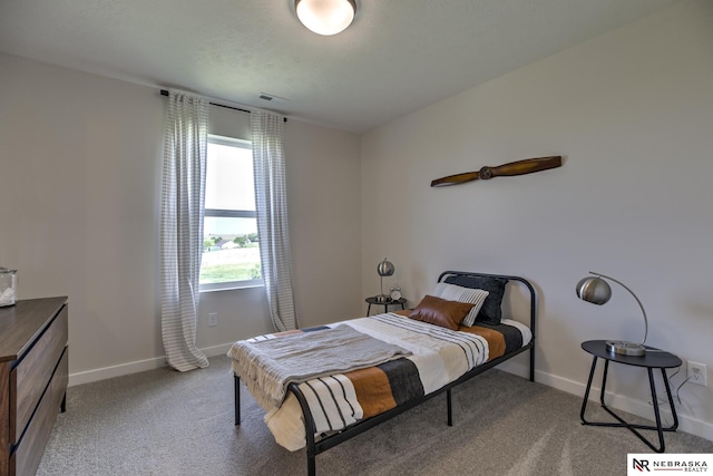 bedroom featuring light colored carpet and a textured ceiling