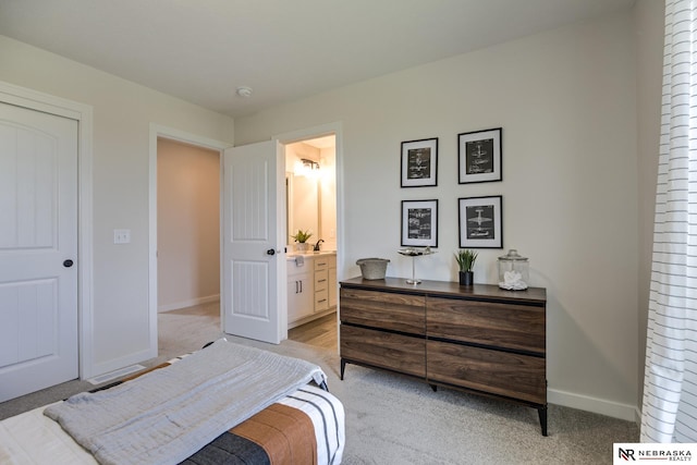 bedroom featuring light carpet and ensuite bath