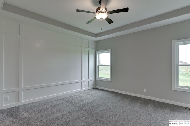 carpeted spare room with ceiling fan and a wealth of natural light