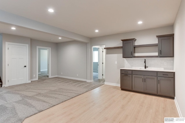 kitchen with sink, light hardwood / wood-style flooring, and decorative backsplash