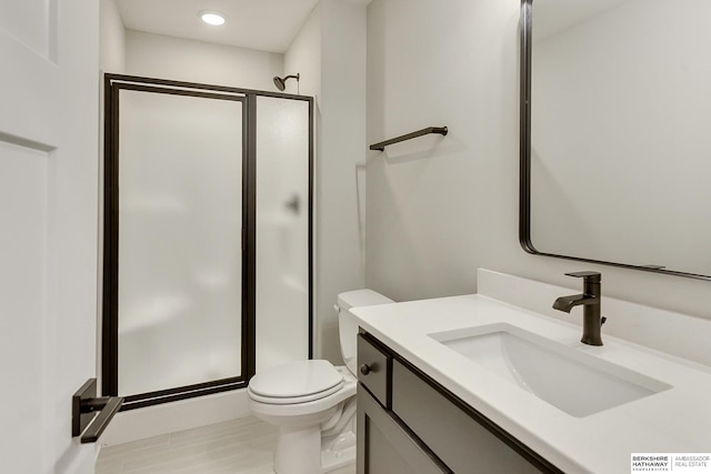 bathroom with vanity, toilet, and an enclosed shower