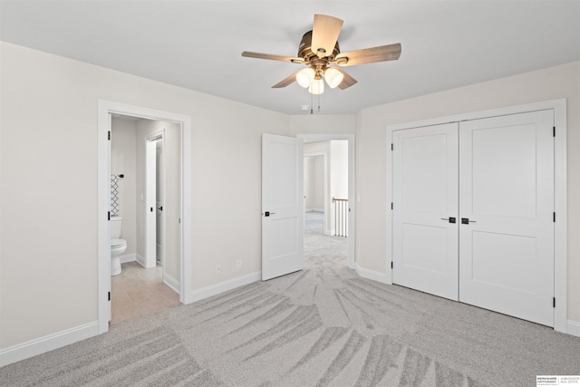 unfurnished bedroom with ceiling fan, a closet, ensuite bath, and light carpet