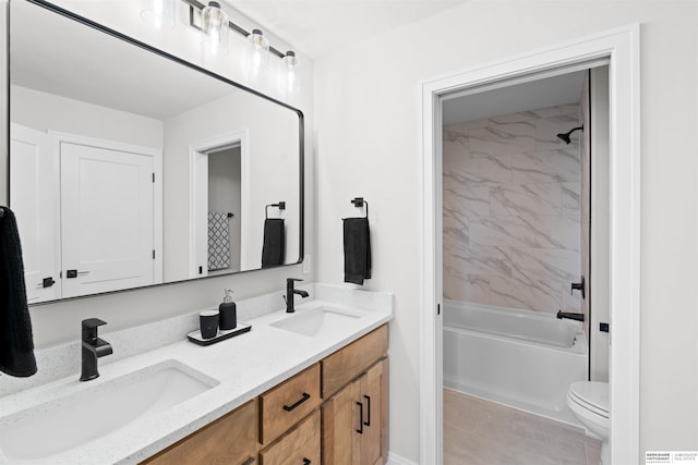 full bathroom featuring tiled shower / bath, vanity, and toilet