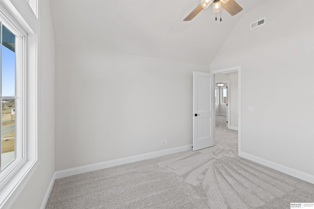 empty room featuring high vaulted ceiling, light colored carpet, and ceiling fan