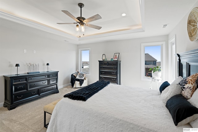 carpeted bedroom featuring ceiling fan and a tray ceiling