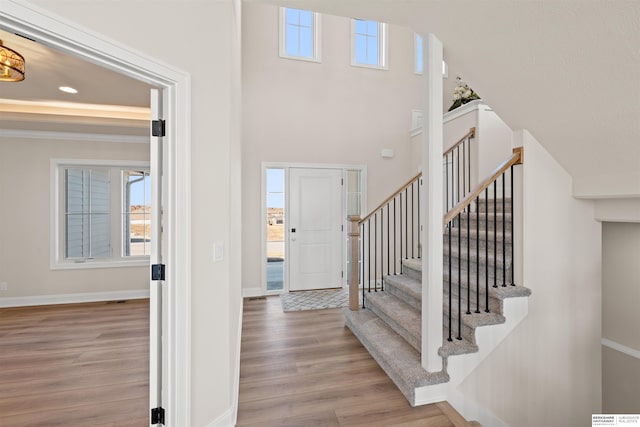 entrance foyer with a towering ceiling and light wood-type flooring