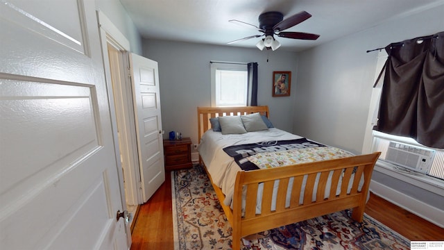 bedroom featuring dark wood-type flooring, ceiling fan, and cooling unit