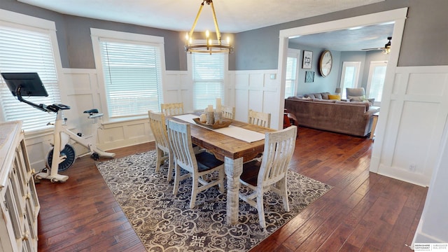 dining room featuring ceiling fan with notable chandelier and dark wood-type flooring