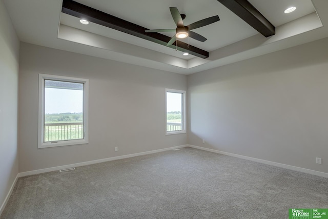 carpeted spare room with ceiling fan and beam ceiling