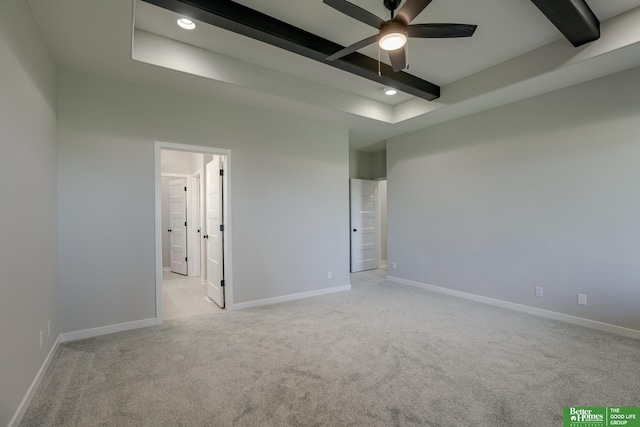 spare room with ceiling fan, light colored carpet, and beam ceiling