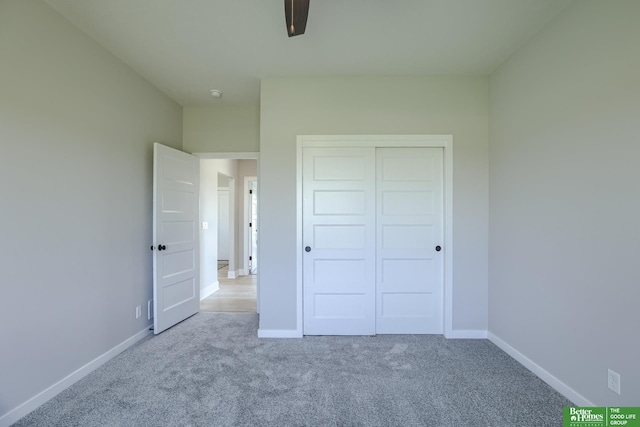 unfurnished bedroom featuring light carpet and a closet