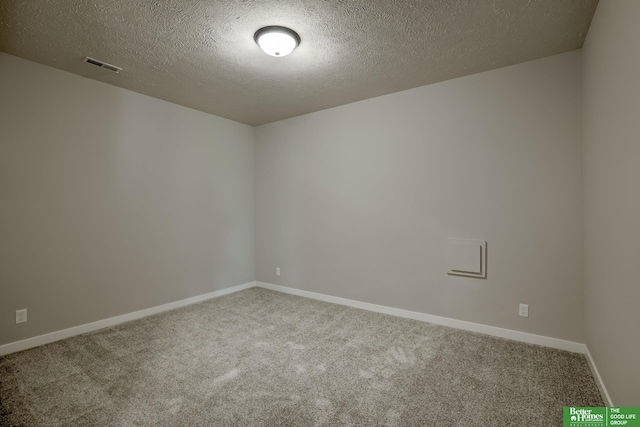 unfurnished room with a textured ceiling and carpet