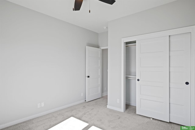 unfurnished bedroom with ceiling fan, baseboards, a closet, and light colored carpet