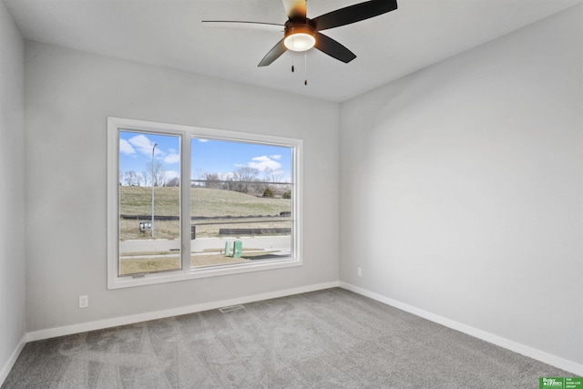 spare room featuring ceiling fan, carpet, and baseboards