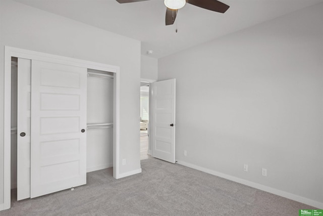 unfurnished bedroom with light carpet, ceiling fan, a closet, and baseboards