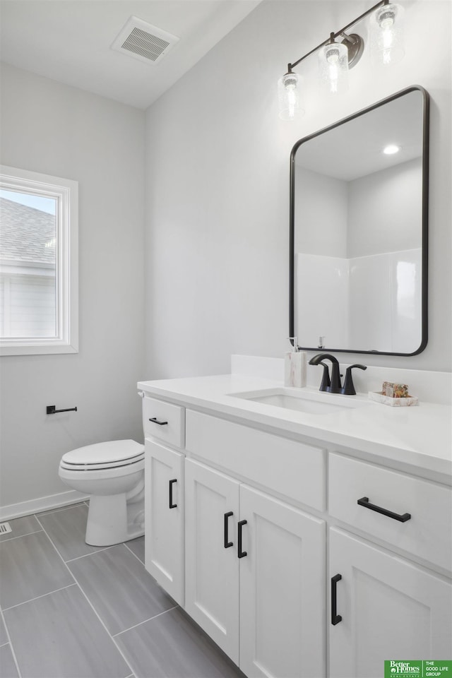 bathroom with toilet, visible vents, and vanity