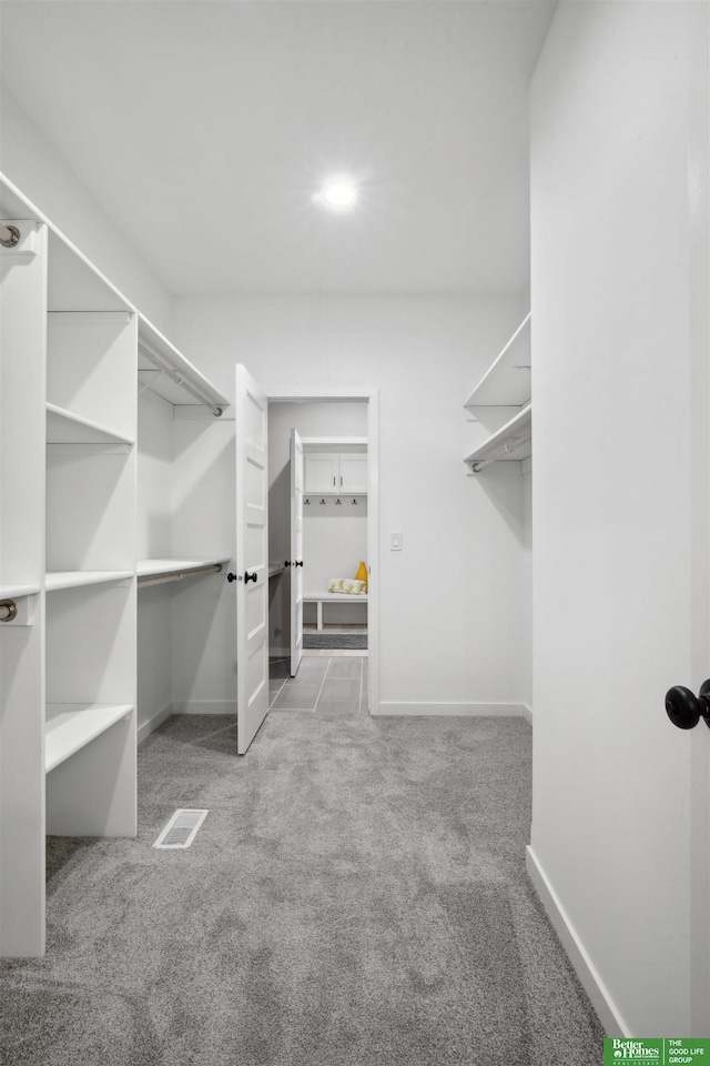 walk in closet featuring light carpet and visible vents