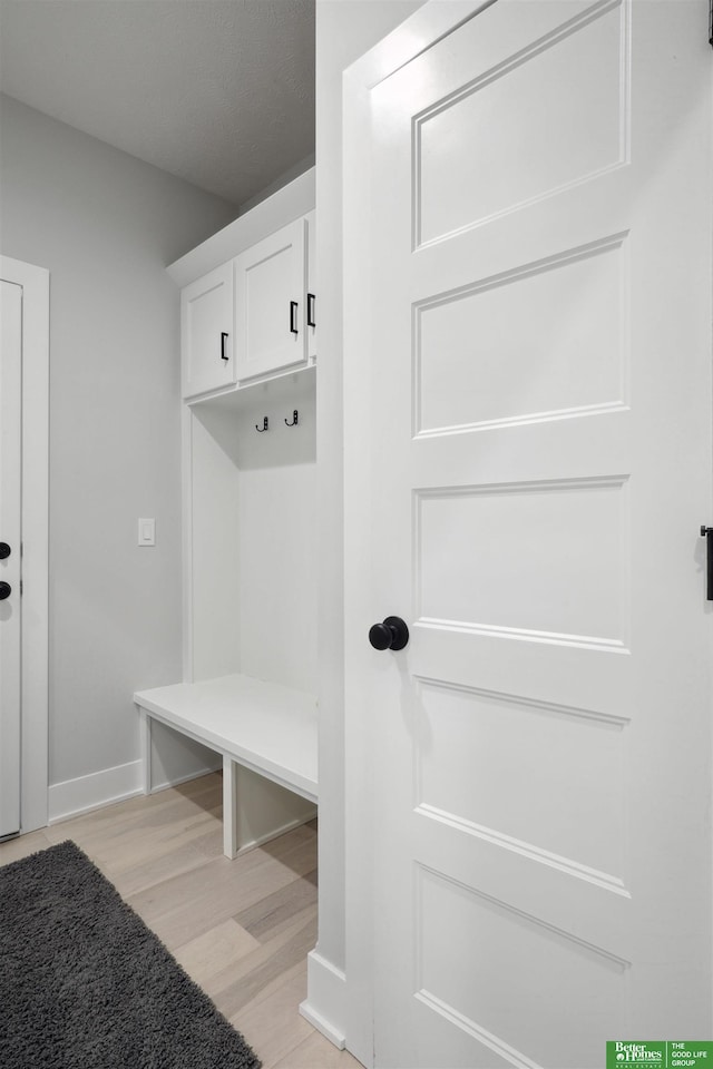 mudroom with light wood-style flooring and baseboards