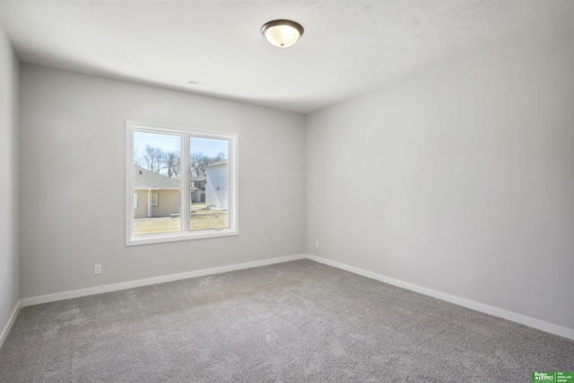 carpeted empty room with baseboards