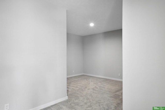 spare room featuring light carpet, recessed lighting, and baseboards