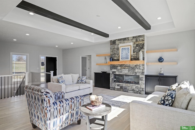 living area with light wood-style flooring, a fireplace, beamed ceiling, and recessed lighting