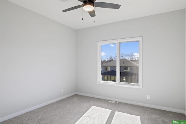 carpeted empty room with visible vents, baseboards, and ceiling fan