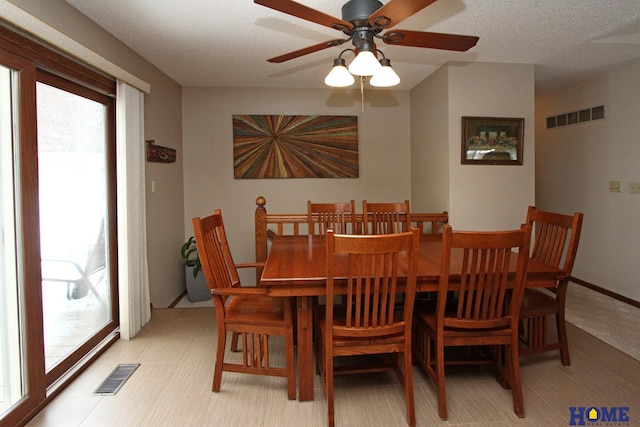 dining room with a textured ceiling, visible vents, and baseboards