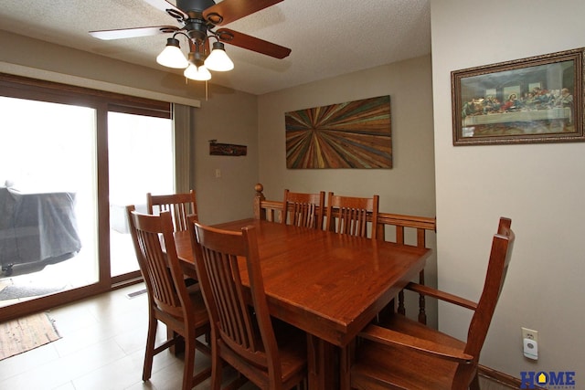 dining space featuring ceiling fan and a textured ceiling