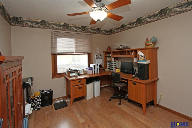 office space with light wood-style floors, ceiling fan, and baseboards