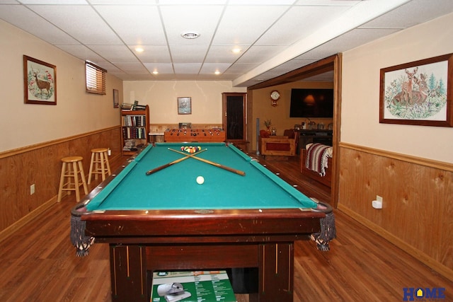 game room with a drop ceiling, a wainscoted wall, pool table, wood walls, and wood finished floors