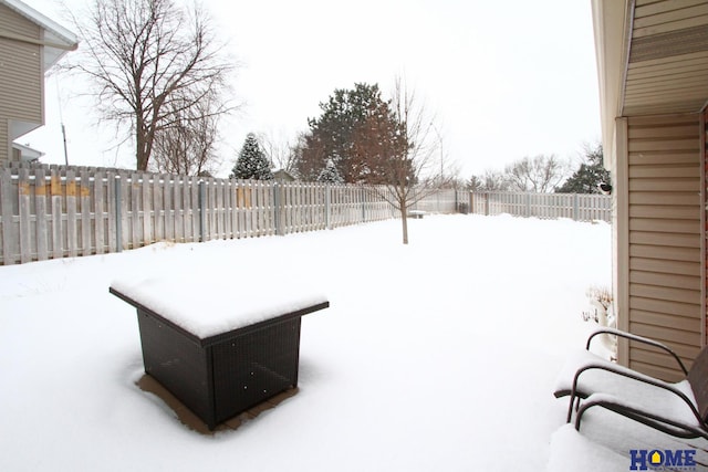 yard covered in snow with a fenced backyard