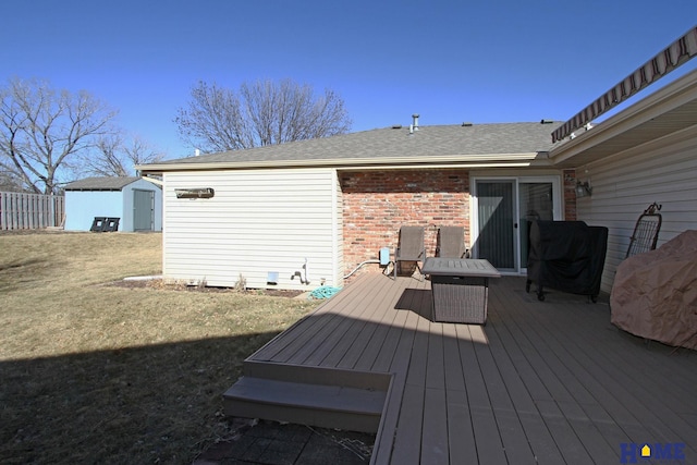 deck with an outbuilding, a yard, a storage shed, and fence