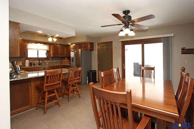 dining room featuring ceiling fan, a textured ceiling, and light floors