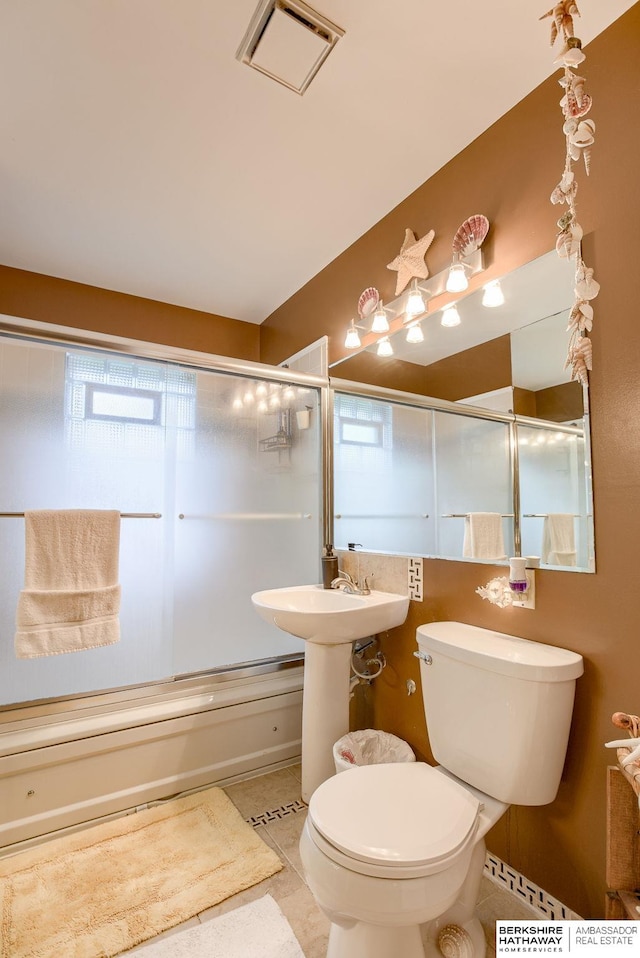 full bathroom featuring sink, tile patterned floors, enclosed tub / shower combo, and toilet