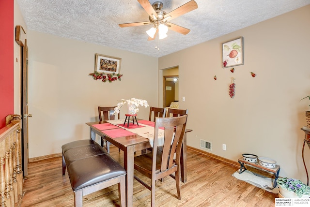 dining room with ceiling fan, a textured ceiling, and light hardwood / wood-style flooring