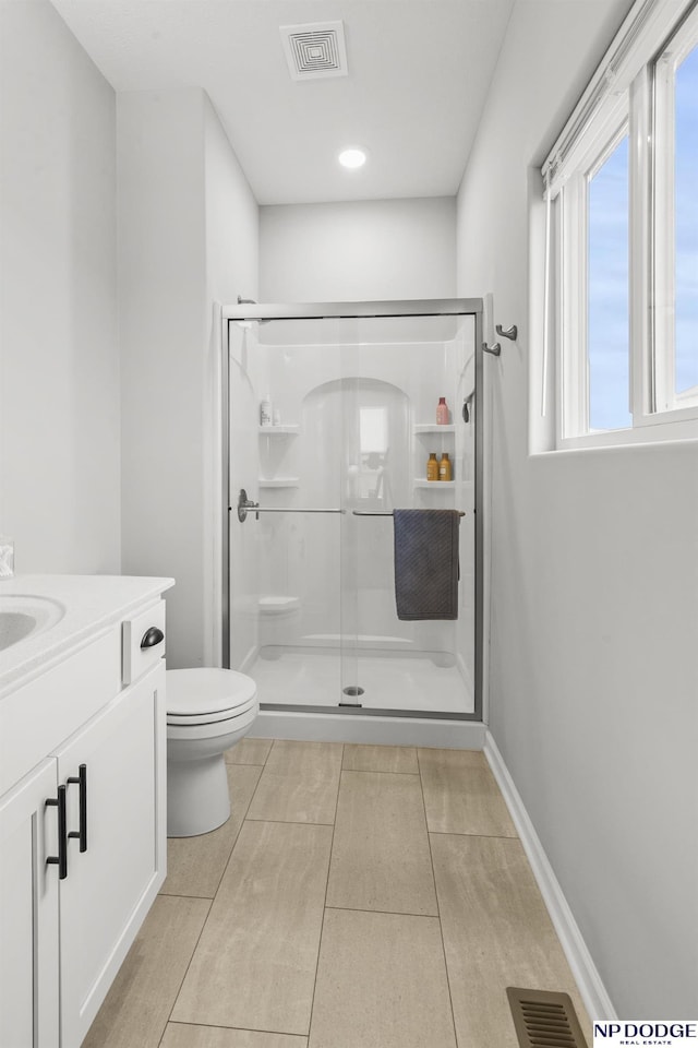 bathroom with walk in shower, vanity, and toilet