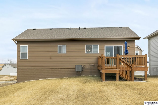 rear view of house with a wooden deck, a yard, and central AC unit